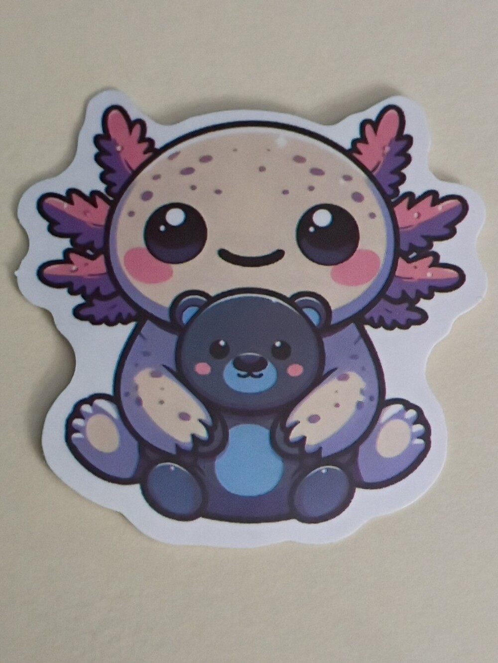 10/$10 Sticker - Axolotl Pink & Purple Color & Freckles - Holding Blue TeddyBear